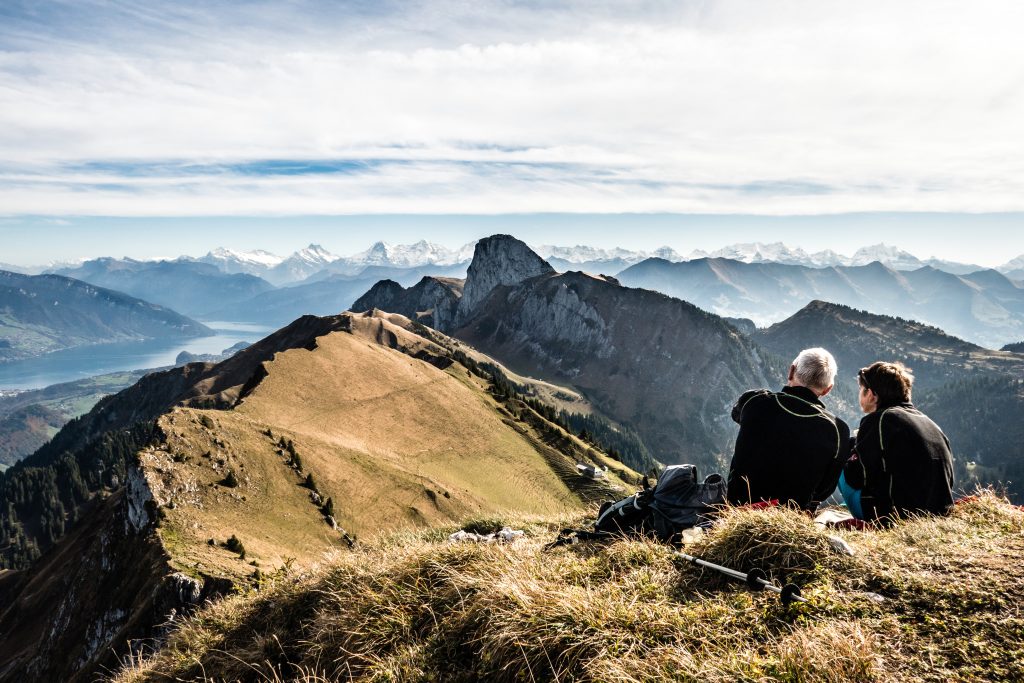 A couple enjoys the view of the Stockhorn, Niesen, Eiger, Mönch and Jungfrau, Bernese Oberland, Switzerland